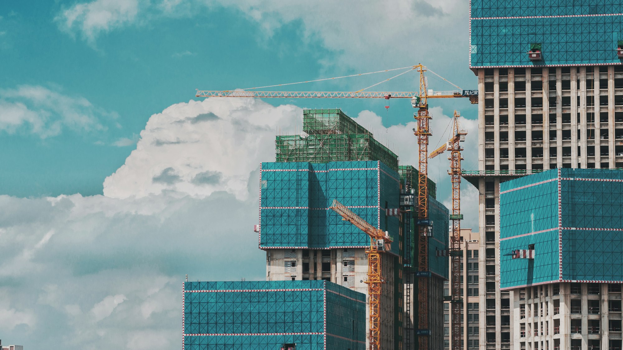 High-rise construction with tower cranes against the sky
